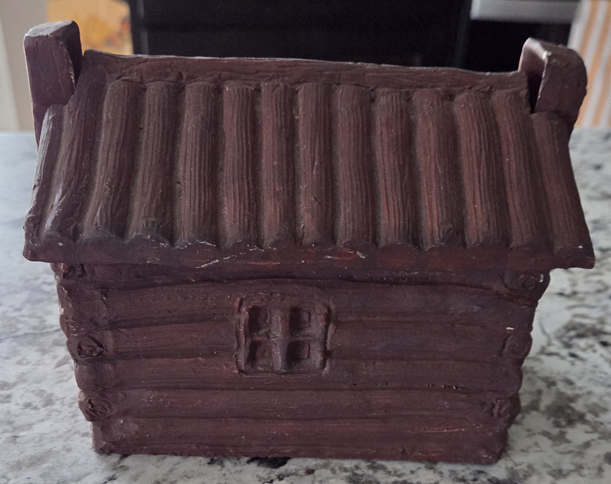 Brown Van Briggle log cabin incense burner seen from the back, with a split-log roof, one four-pane window and a chimney at each end