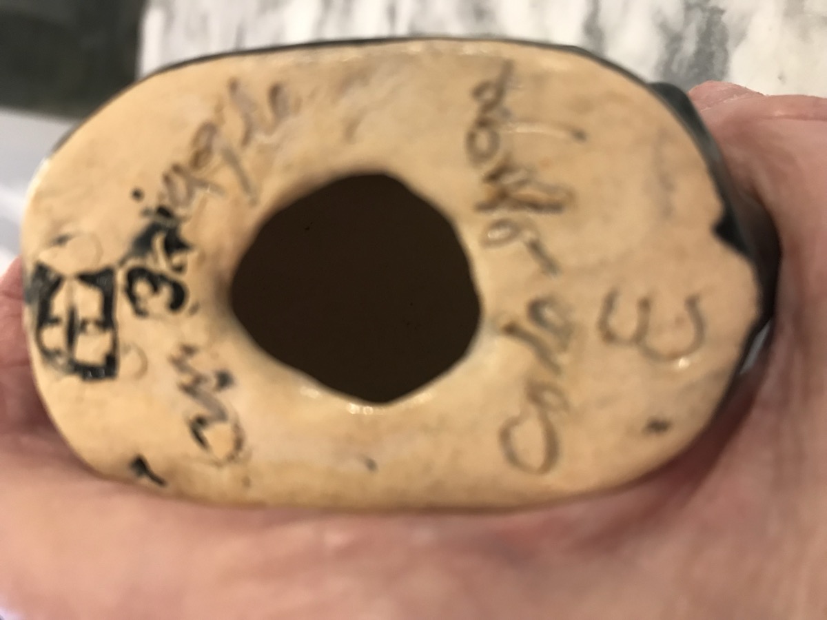 Bottom marks of Van Briggle swan planter showing squared AA monogram and cursive Van Briggle Colo Spgs on buff clay