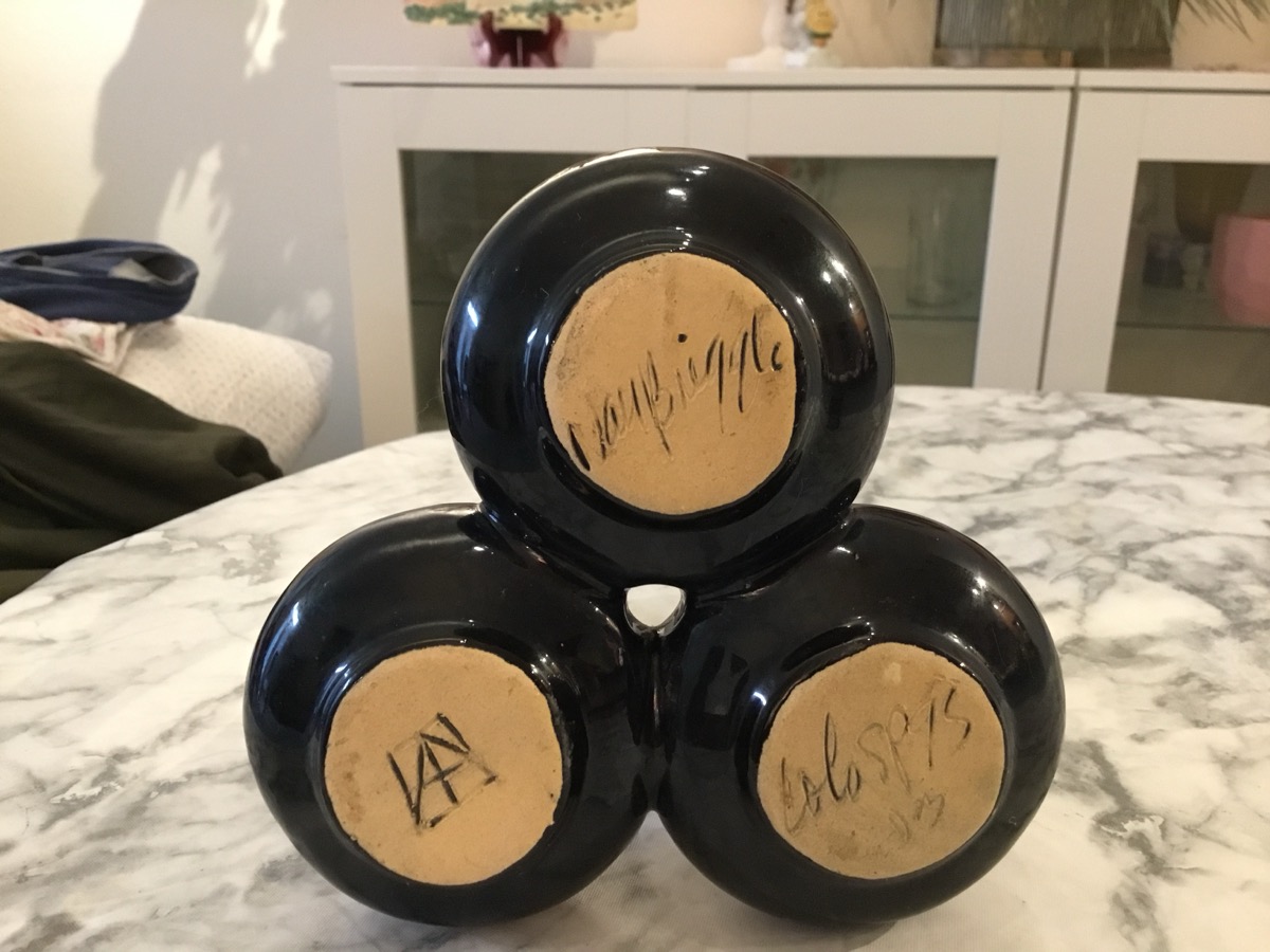 Bottom marks of Van Briggle triple bud vase showing three buff-clay feet with squared AA monogram and cursive Van Briggle Colo Spgs
